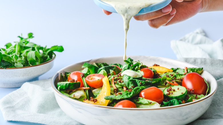 pouring dressing on a salad