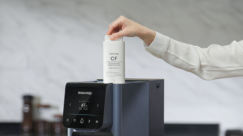 Person changes Waterdrop countertop water filter.