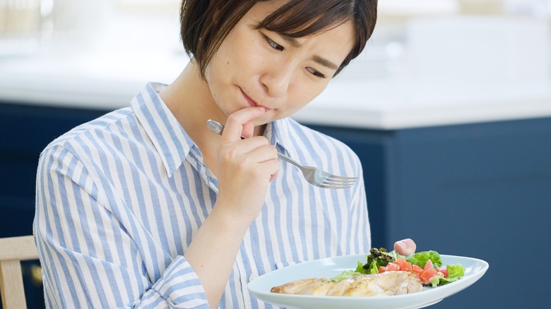 Woman looking at food with suspicion