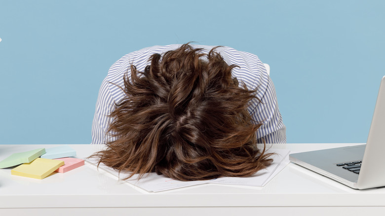 tired woman with head on desk