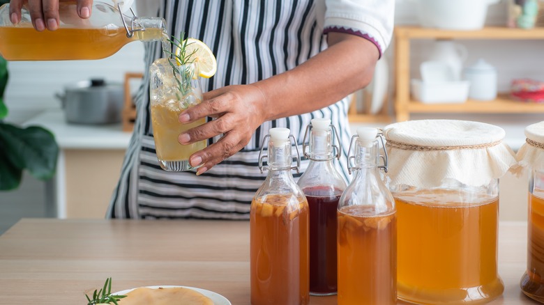 Person pouring kombucha into glass