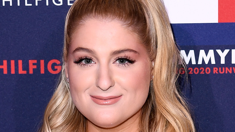 Meghan Trainor smiling and holding microphone