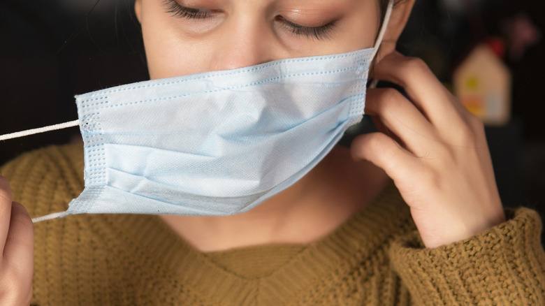 woman removing face mask