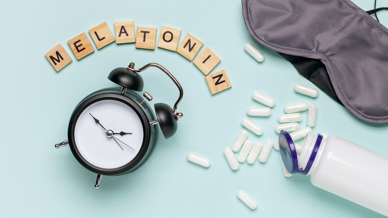 Word "melatonin" with pills, mask, clock