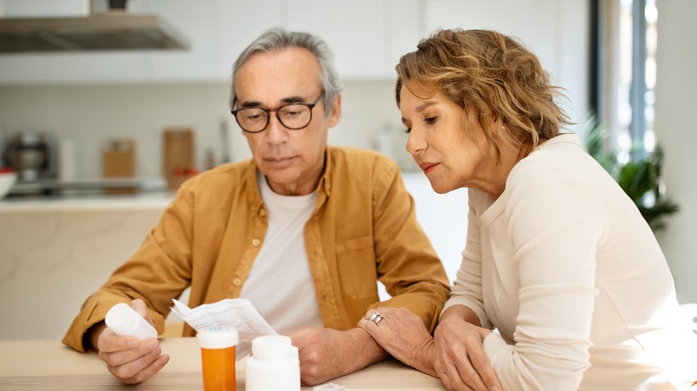 Elderly couple reading drug pamphlet
