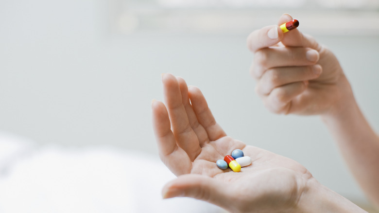 Hand holding variety of pills