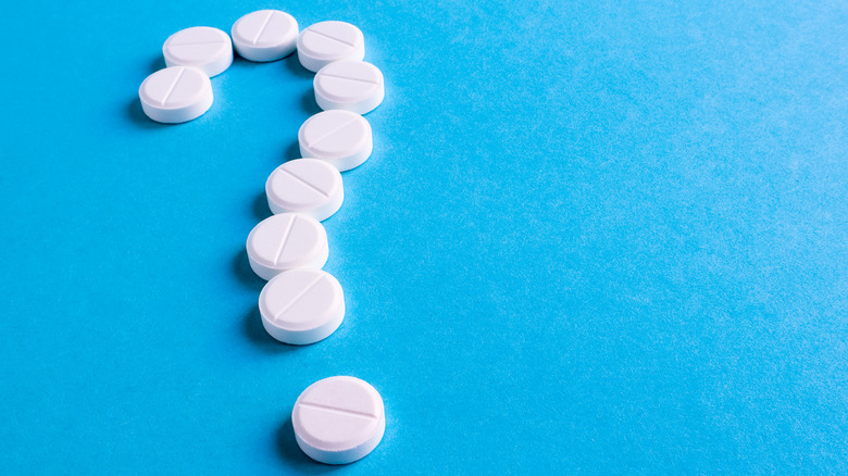 White tablets in the shape of a question mark