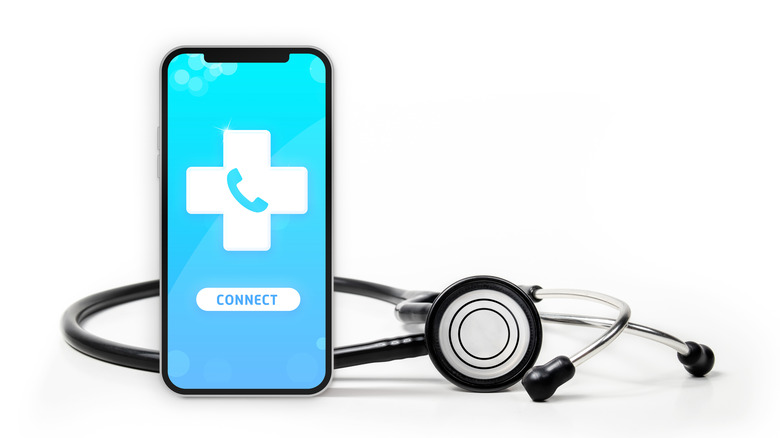 Phone with medical cross and a stethoscope in the background