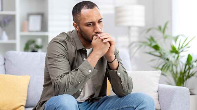 Worried man sitting on couch