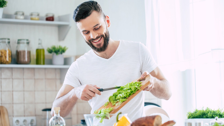 Fit man making a salad with fresh vegetables