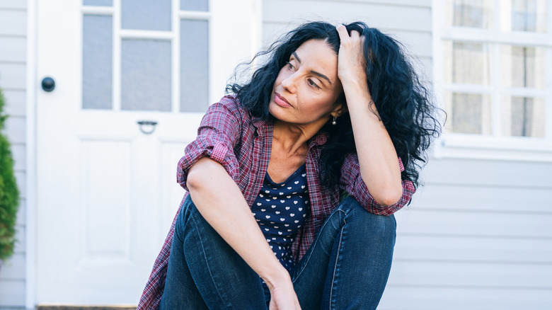 woman sitting on front steps of a home