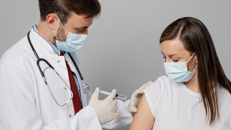 Doctor giving vaccine to patient