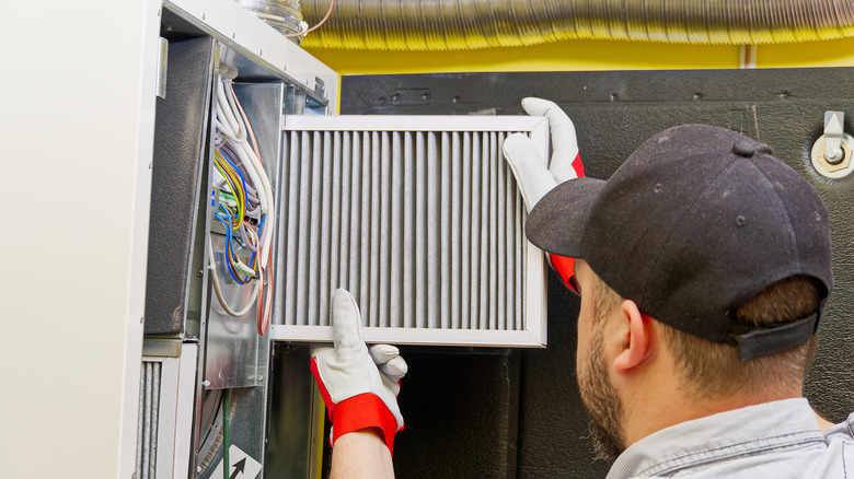 HVAC technician changing air filter