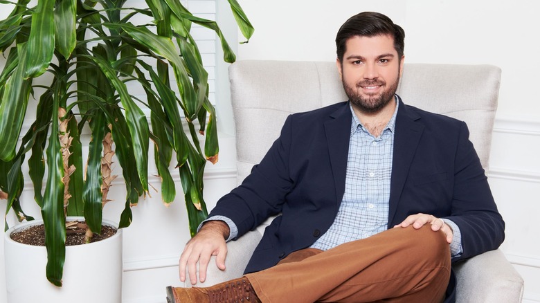 Michael Rubino smiling and sitting in armchair