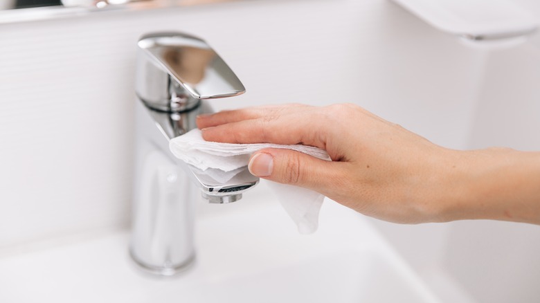 Hand wiping a faucet
