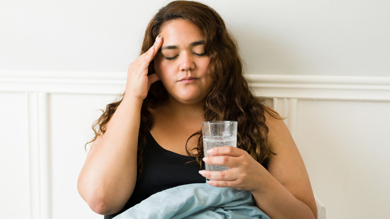 Woman holding head in pain