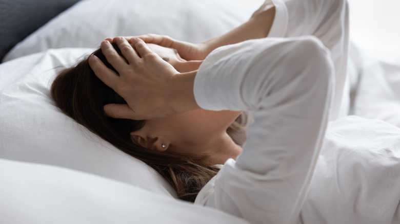 woman in bed suffering a migraine