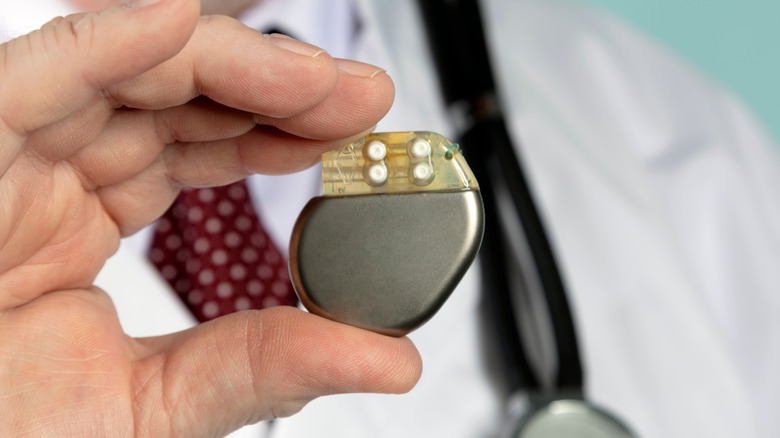 male hand holding up a pacemaker 