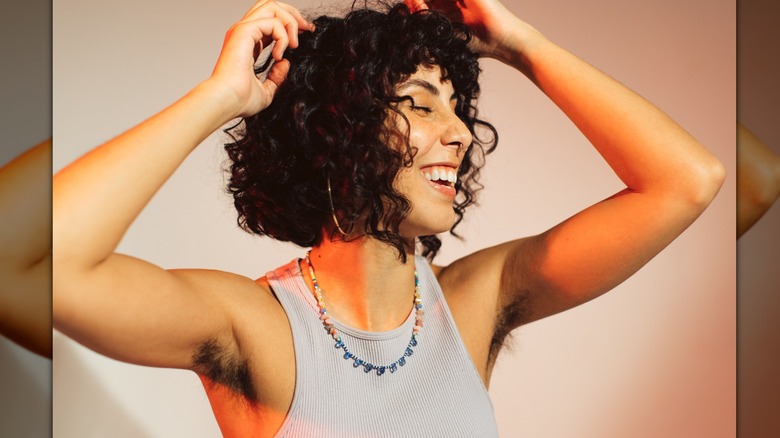 Woman smiling and showing off her underarm hair