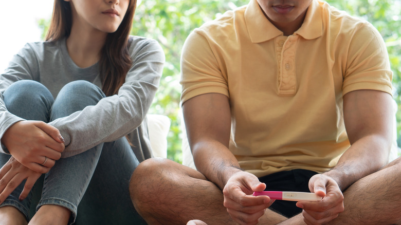 couple looks at pregnancy test