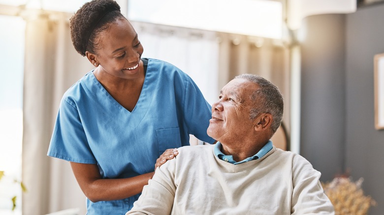 nurse tending to older adult in a wheelchair