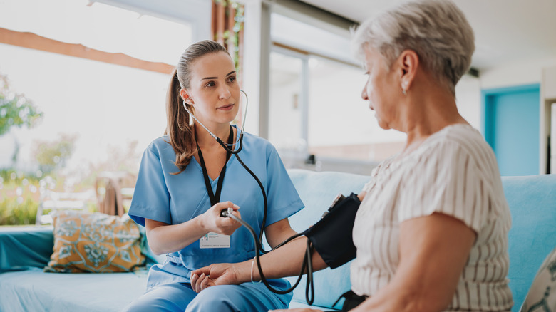nurse checking woman's blood pressure