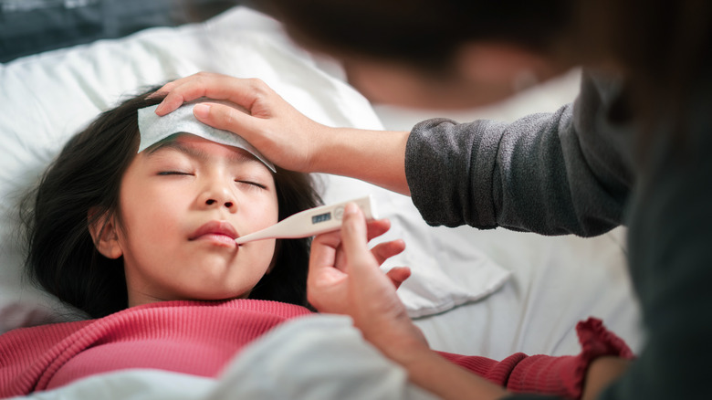 Child with temperature getting a compress