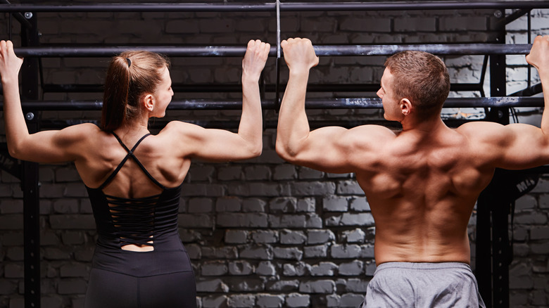 man and a woman doing pull-ups