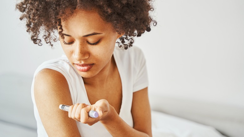 woman injecting insulin in her arm