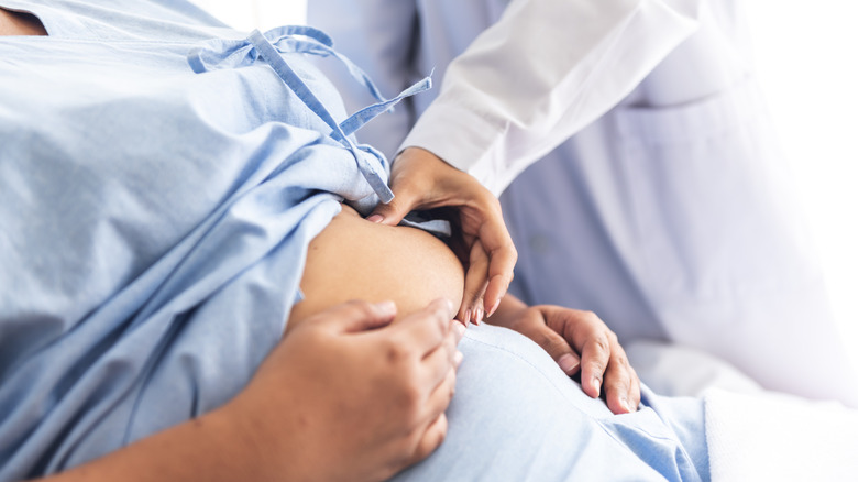 Doctor's hand holding patient's belly