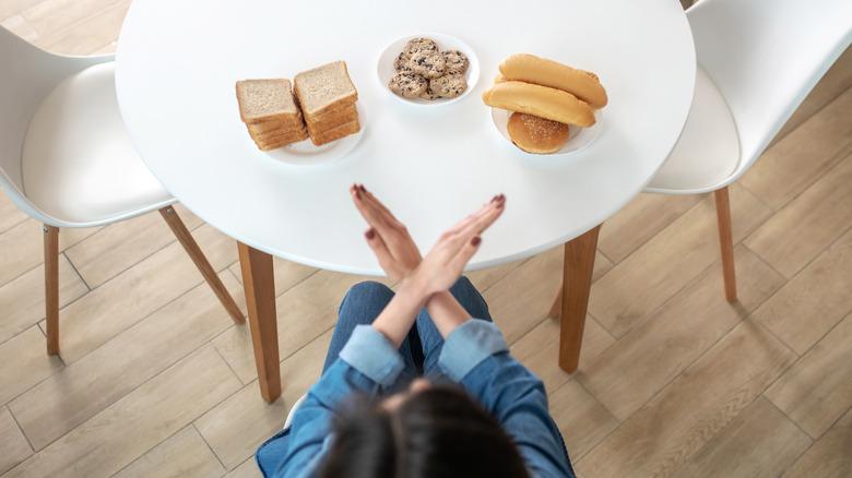 woman refusing to eat bread and cookies