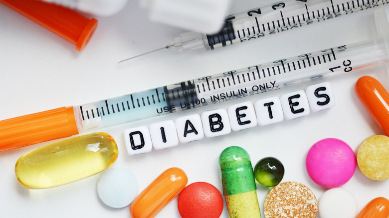 Diabetes spelled in beads next to pills and seringe