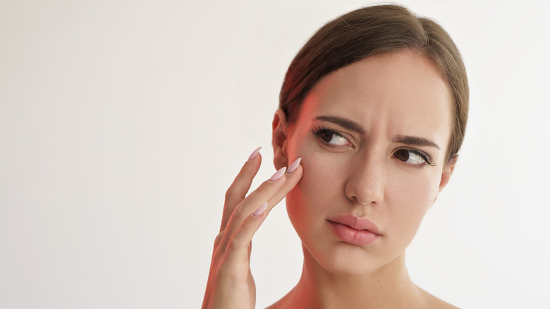 woman touching her face 