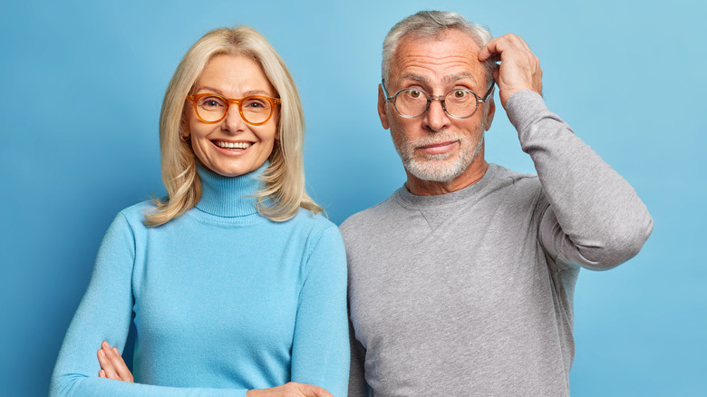 smiling and perplexed middle-aged couple