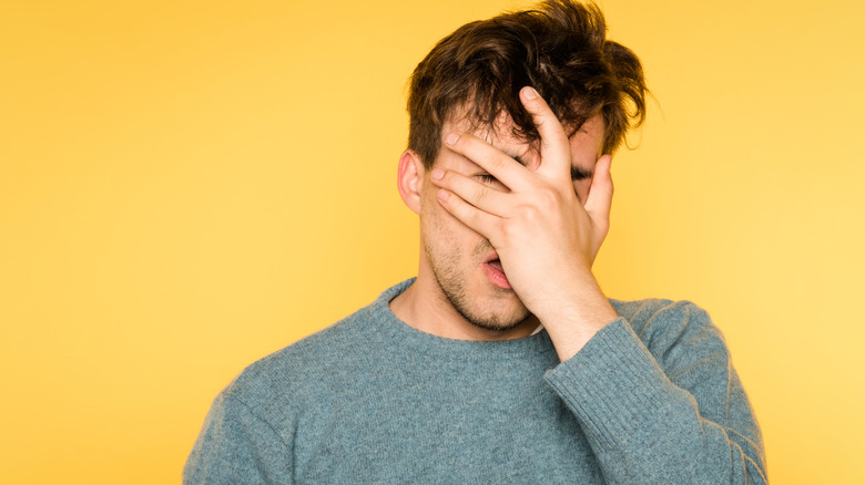 hopeless man hiding his face