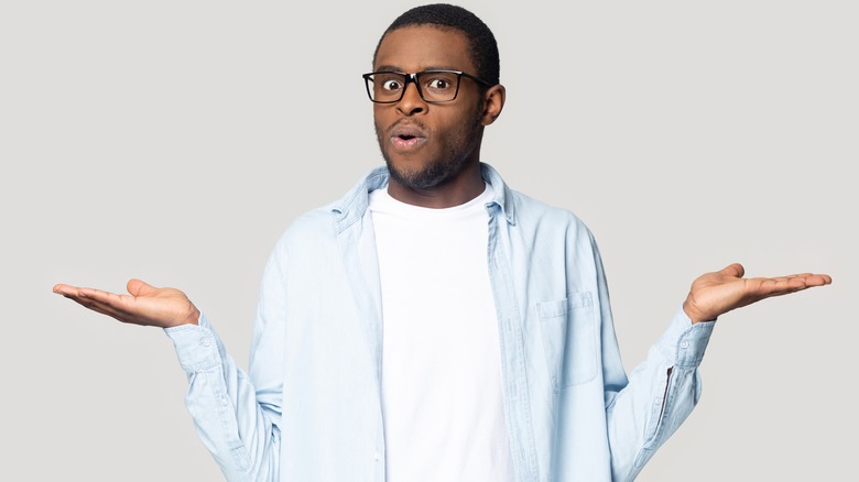 surprised and shocked young man with hands outstretched
