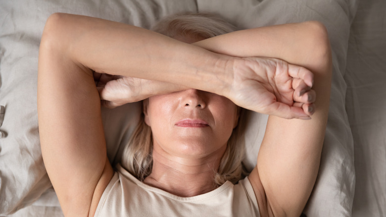 woman with arms covering forehead