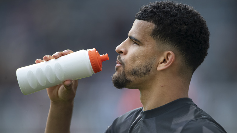 athlete drinking water from bottle