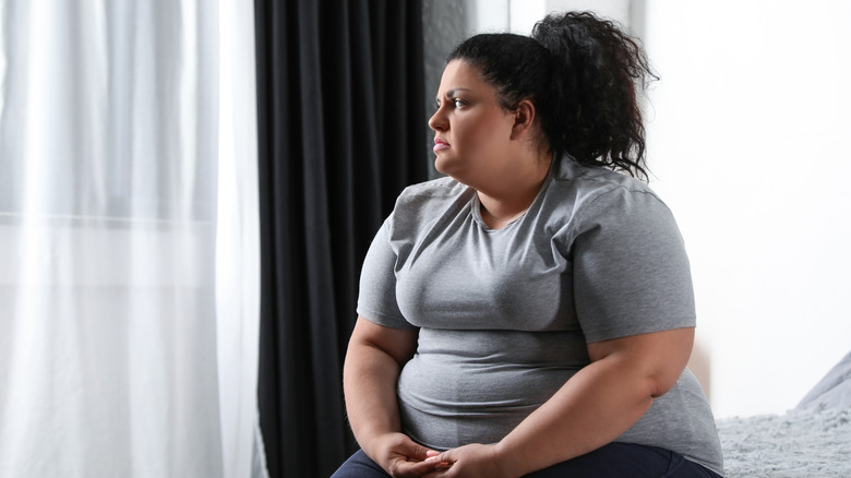 Obese woman looking through the window