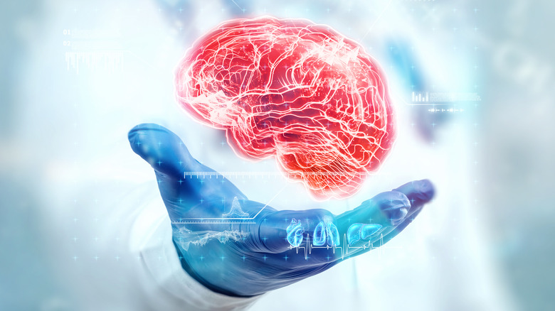 doctor's gloved hand under brain hologram 