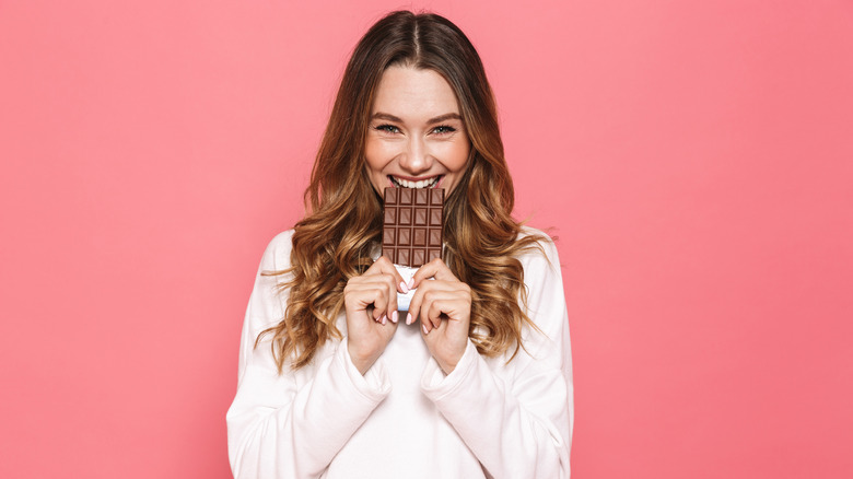 Woman biting chocolate bar