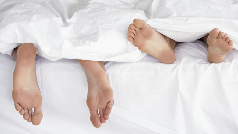 Couple in bed under blanket