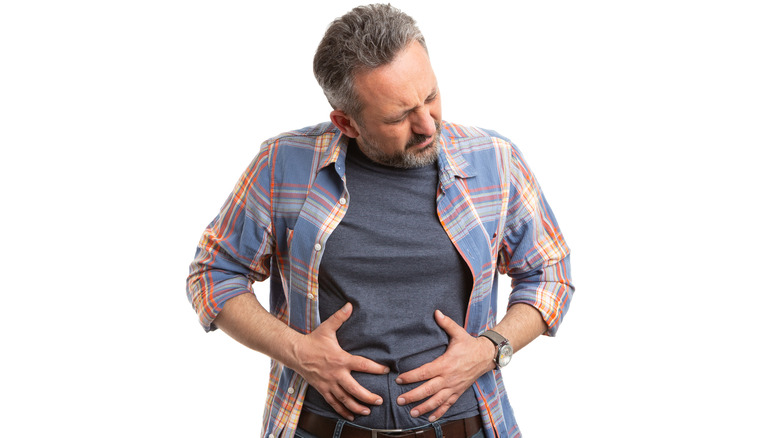 Man holding bloated stomach