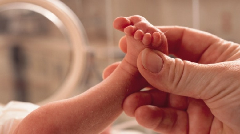 mother grabs baby's foot 