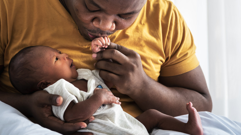 Father kissing baby's hand