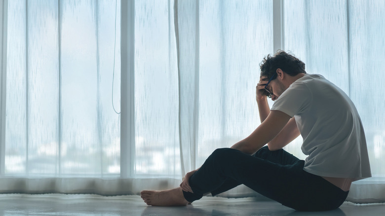 A depressed man sitting on the floor