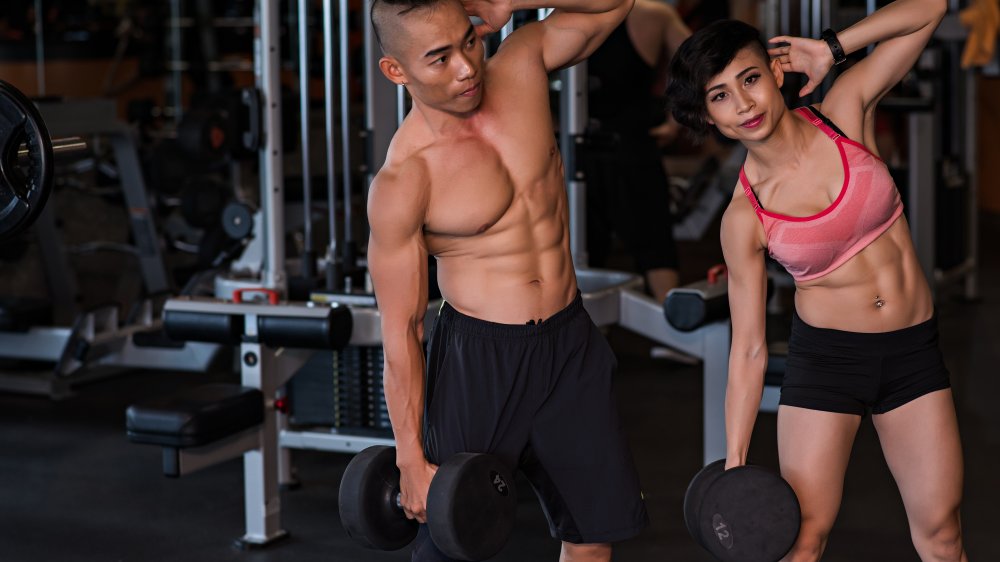 couple doing dumbbell side bends