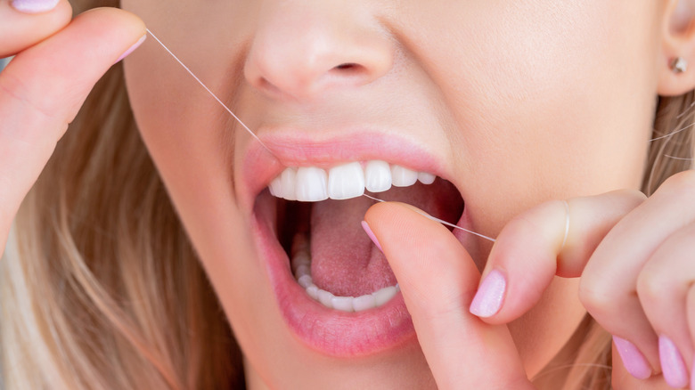 Woman flossing her teeth