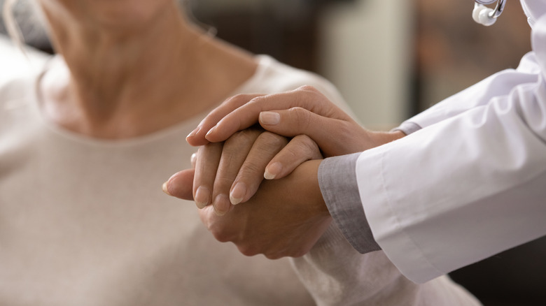 doctor holding the hand of a cancer patient