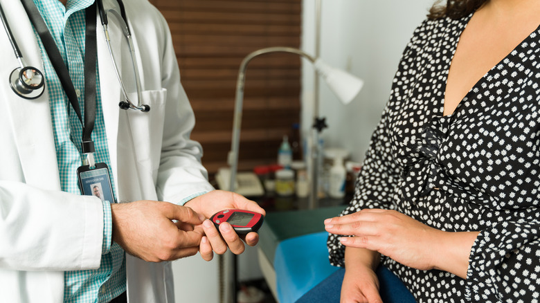 Doctor measuring patient's blood sugar